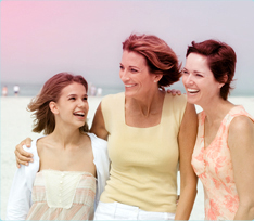 Billede af tre kvinde, der holder om hinanden, en yngre kvinde til venstre og to ældre kvinder til højre.