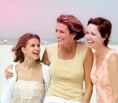 Billede af tre kvinde, der holder om hinanden, en yngre kvinde til venstre og to ældre kvinder til højre.